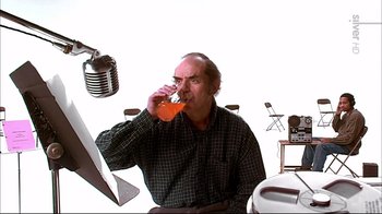 Movie still from “American Splendor” (2003), directed by Shari Springer Berman – An older man drinking a drink from a glass; Medium shot, Low angle