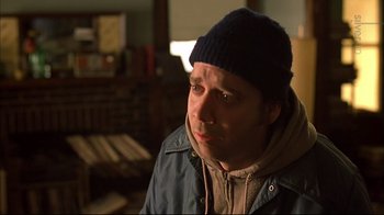Movie still from “American Splendor” (2003), directed by Shari Springer Berman – A man wearing a blue hat and a jacket; Close Up shot, Over the shoulder angle