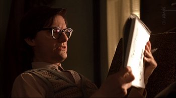 Movie still from “American Splendor” (2003), directed by Shari Springer Berman – A man with glasses is holding a book in his hand; Close Up shot, Low angle