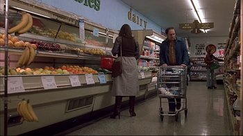 Movie still from “American Splendor” (2003), directed by Shari Springer Berman – A man and a woman shopping in a grocery store; Wide shot, Low angle