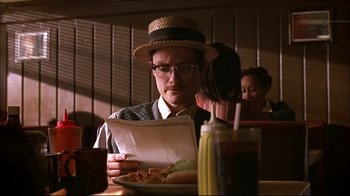 Movie still from “American Splendor” (2003), directed by Shari Springer Berman – A man sitting at a table with a plate of food; Close Up shot, Low angle