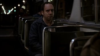 Movie still from “American Splendor” (2003), directed by Shari Springer Berman – A man sitting on a bus looking at the camera; Medium shot, High angle