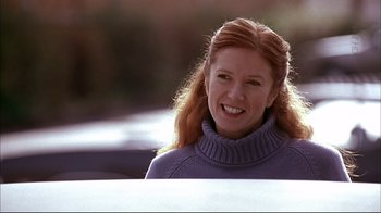 Movie still from “American Splendor” (2003), directed by Shari Springer Berman – A woman with red hair smiling for the camera; Close Up shot, Over the shoulder angle