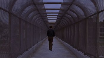 Movie still from “American Splendor” (2003), directed by Shari Springer Berman – A man is walking down a long walkway; Wide shot, Low angle