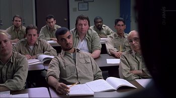 Movie still from “American Splendor” (2003), directed by Shari Springer Berman – A group of men sitting at a table in front of a book; Medium shot, High angle
