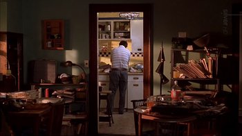 Movie still from “American Splendor” (2003), directed by Shari Springer Berman – A man standing in front of an oven in a kitchen; Wide shot, High angle