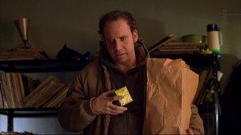 Movie still from “American Splendor” (2003), directed by Shari Springer Berman – A man in a brown jacket holding a brown paper bag; Medium shot, Low angle