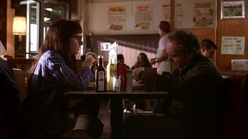Movie still from “American Splendor” (2003), directed by Shari Springer Berman – A man and a woman sitting at a table in a restaurant; Medium shot, High angle