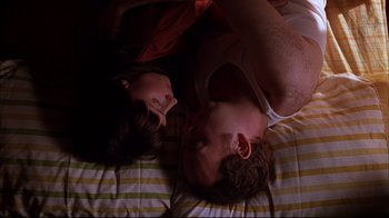Movie still from “American Splendor” (2003), directed by Shari Springer Berman – A man and a woman laying on a bed together; Medium shot, Overhead angle
