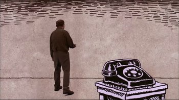 Movie still from “American Splendor” (2003), directed by Shari Springer Berman – A man standing in front of a phone booth; Extreme Wide shot, Overhead angle