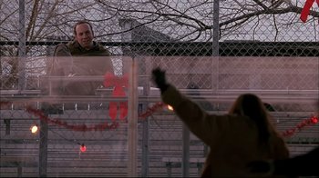 Movie still from “American Splendor” (2003), directed by Shari Springer Berman – A man is standing behind a chain link fence; Medium shot, Over the shoulder angle