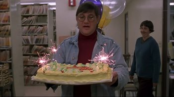 Movie still from “American Splendor” (2003), directed by Shari Springer Berman – A woman holding a birthday cake with sparklers on it; Medium shot, Low angle