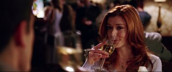 Movie still from “American Wedding” (2003), directed by Jesse Dylan – A woman holding a glass of wine at a party; Close Up shot, Over the shoulder angle