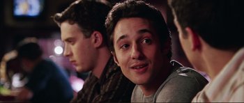 Movie still from “American Wedding” (2003), directed by Jesse Dylan – Two young men sitting next to each other in front of a building; Close Up shot, Over the shoulder angle