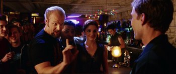 Movie still from “American Wedding” (2003), directed by Jesse Dylan – A man and a woman posing for a picture in a bar; Medium shot, Over the shoulder angle