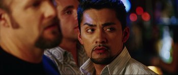 Movie still from “American Wedding” (2003), directed by Jesse Dylan – A man staring at the camera while another man looks on; Close Up shot, Over the shoulder angle