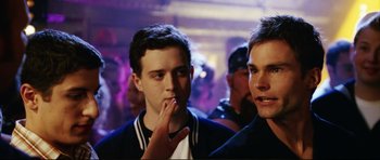 Movie still from “American Wedding” (2003), directed by Jesse Dylan – Two young men standing next to each other in front of a crowd of onlookers; Close Up shot, Over the shoulder angle