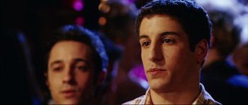 Movie still from “American Wedding” (2003), directed by Jesse Dylan – Two young men standing next to each other in front of lights; Close Up shot, Over the shoulder angle