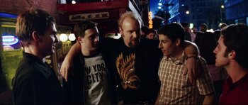 Movie still from “American Wedding” (2003), directed by Jesse Dylan – A group of men standing next to each other on the street; Medium shot, Over the shoulder angle
