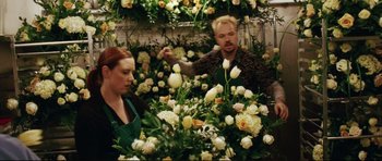 Movie still from “American Wedding” (2003), directed by Jesse Dylan – A man and a woman working in a flower shop; Medium shot, High angle