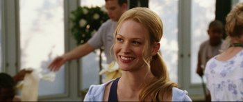 Movie still from “American Wedding” (2003), directed by Jesse Dylan – A woman with long blonde hair smiling for the camera; Close Up shot, Over the shoulder angle