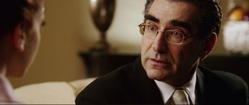 Movie still from “American Wedding” (2003), directed by Jesse Dylan – A person wearing a suit and glasses; Close Up shot, Over the shoulder angle