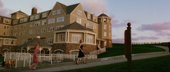 Movie still from “American Wedding” (2003), directed by Jesse Dylan – A woman in a black dress walking in front of a building; Extreme Wide shot, Low angle