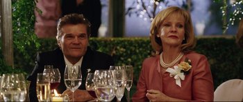Movie still from “American Wedding” (2003), directed by Jesse Dylan – A man and a woman sitting next to each other at a dinner table; Close Up shot, Over the shoulder angle