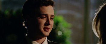 Movie still from “American Wedding” (2003), directed by Jesse Dylan – A young man in a suit is looking into the distance; Close Up shot, Low angle