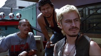 Movie still from “Amores Perros” (2000), directed by Alejandro G. Iñárritu – A group of men standing next to each other; Medium shot, Low angle