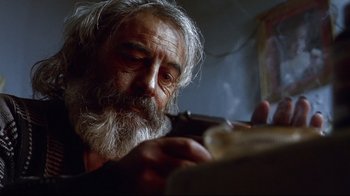 Movie still from “Amores Perros” (2000), directed by Alejandro G. Iñárritu – An old man smoking a pipe in a room; Close Up shot, Low angle