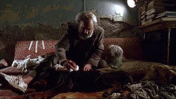 Movie still from “Amores Perros” (2000), directed by Alejandro G. Iñárritu – An old man sitting on a couch with a dog; Wide shot, High angle