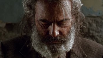 Movie still from “Amores Perros” (2000), directed by Alejandro G. Iñárritu – An old man with a beard is looking down at his face; Close Up shot, Overhead angle