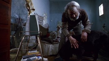 Movie still from “Amores Perros” (2000), directed by Alejandro G. Iñárritu – An old man is standing in a messy room; Medium shot, Low angle