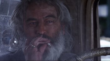 Movie still from “Amores Perros” (2000), directed by Alejandro G. Iñárritu – An old man smoking a cigarette while looking at the camera; Close Up shot, Over the shoulder angle