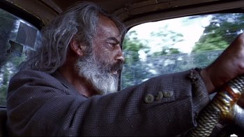 Movie still from “Amores Perros” (2000), directed by Alejandro G. Iñárritu – An older man with a beard driving in a car; Close Up shot, Low angle