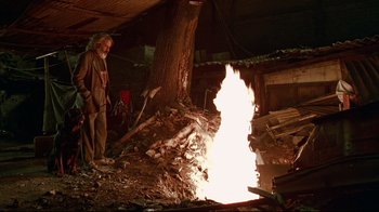 Movie still from “Amores Perros” (2000), directed by Alejandro G. Iñárritu – A man standing in front of a fire in a barn; Wide shot, Low angle