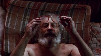 Movie still from “Amores Perros” (2000), directed by Alejandro G. Iñárritu – An older man with a beard and glasses; Close Up shot, Overhead angle