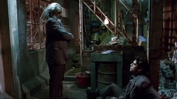 Movie still from “Amores Perros” (2000), directed by Alejandro G. Iñárritu – Two men sitting in a room next to each other; Wide shot, High angle