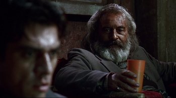Movie still from “Amores Perros” (2000), directed by Alejandro G. Iñárritu – An old man with a beard holding an orange cup; Close Up shot, Over the shoulder angle