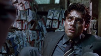 Movie still from “Amores Perros” (2000), directed by Alejandro G. Iñárritu – A man in a suit and tie sitting in front of a bunch of mail; Close Up shot, Low angle