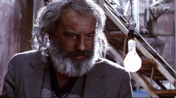 Movie still from “Amores Perros” (2000), directed by Alejandro G. Iñárritu – An old man with a beard and a suit; Close Up shot, Low angle