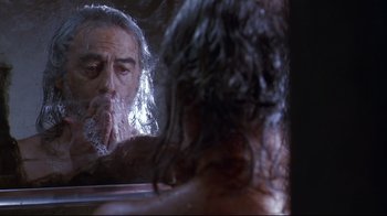 Movie still from “Amores Perros” (2000), directed by Alejandro G. Iñárritu – An older man looking in the mirror in front of a woman; Close Up shot, Low angle