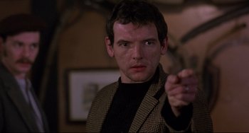 Movie still from “An American Werewolf in London” (1981), directed by John Landis – A man in a brown jacket is pointing at the camera; Close Up shot, Over the shoulder angle