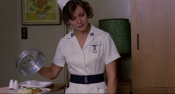 Movie still from “An American Werewolf in London” (1981), directed by John Landis – A woman in a nurse's uniform is holding a plate; Medium shot, Low angle