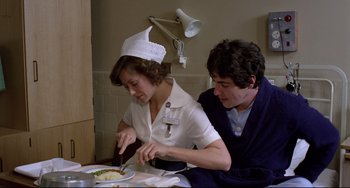 Movie still from “An American Werewolf in London” (1981), directed by John Landis – A woman in a nurse's hat cutting a piece of food; Medium shot, Low angle