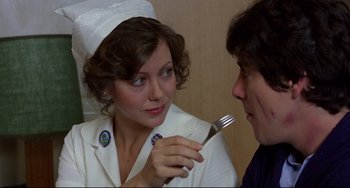 Movie still from “An American Werewolf in London” (1981), directed by John Landis – A woman holding a fork in front of a man; Close Up shot, Over the shoulder angle