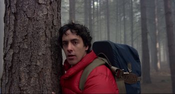 Movie still from “An American Werewolf in London” (1981), directed by John Landis – A man with a backpack leaning against a tree; Close Up shot, Low angle