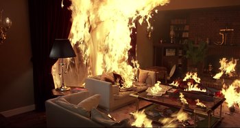 Movie still from “An American Werewolf in London” (1981), directed by John Landis – A living room with a couch and a table on fire; Wide shot, High angle