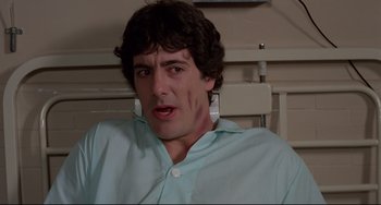 Movie still from “An American Werewolf in London” (1981), directed by John Landis – A man in a blue button up shirt and white earrings; Close Up shot, Low angle